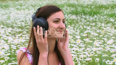 A girl listens to music on the field