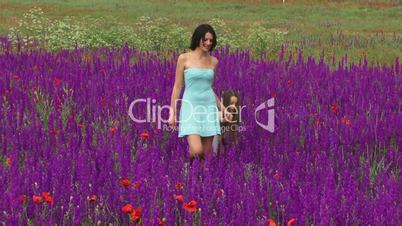 Girls are walking among the flowers