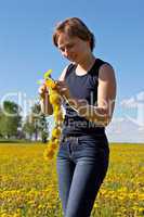 woman twining a dandelion wreath