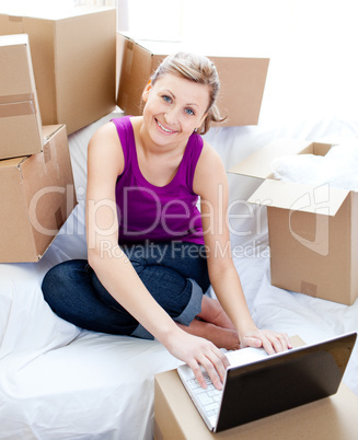 Cute woman using a laptop in the living-room