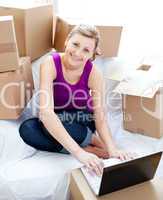 Cute woman using a laptop in the living-room