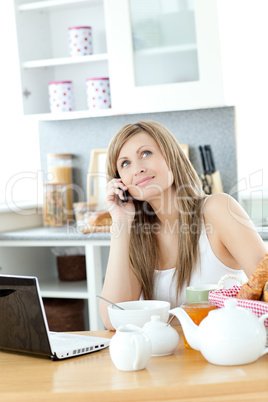 Pensive woman having a breakfast in the kitchen