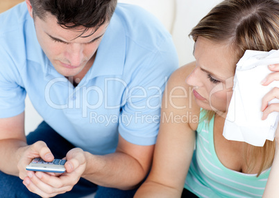 Adorable couple using a remote in the living-room