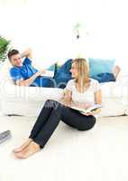 Happy couple reading book in the living-room