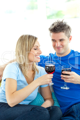 Adorable couple drinking wine together in the living-room