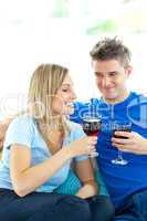 Adorable couple drinking wine together in the living-room