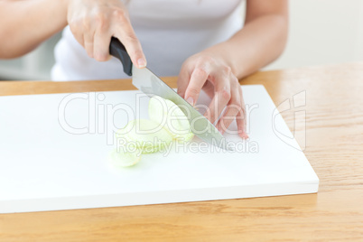 Delighted woman preparing onion in the kitchen