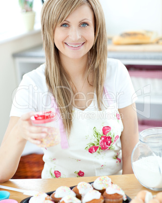 Attractive woman showing cakes in the kitchen