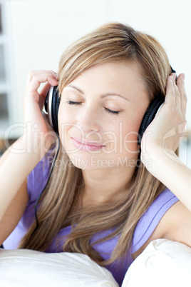 Portrait of a cheerful woman listening music in the kitchen