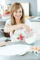 Portrait of a cheerful woman preparing a cake in the kitchen