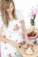 Attractive woman cutting bread in the kitchen