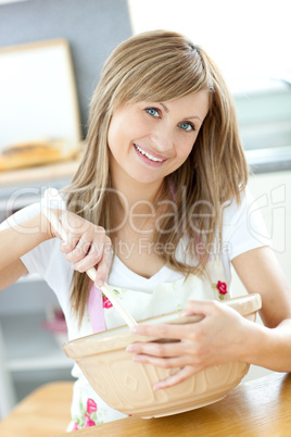 Portrait of a cute woman showing a cake in the kitchen