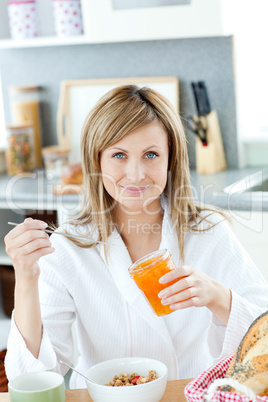 Delighted woman having breakfast in the kitchen