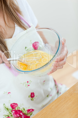 Close-up of a teen woman preparing a cake in the kitchen