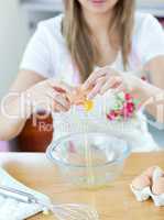 Close-up of a young woman preparing a cake in the kitchen
