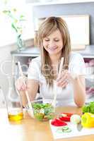 Radiant woman preparing a salad in the kitchen