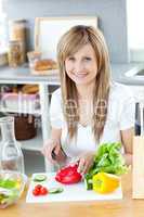 Teen woman preparing a salad in the kitchen