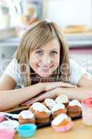 Delighted woman eating cakes in the kitchen