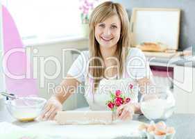 Delighted woman is preparing a cake in the kitchen