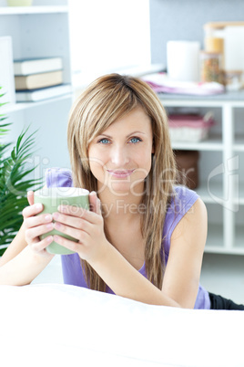 Young woman holding a cup of coffee in the kitchen