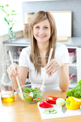 Cute woman preparing a salad in the kitchen