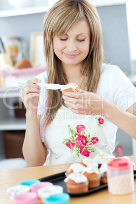 Delighted woman preparing cakes in the kitchen