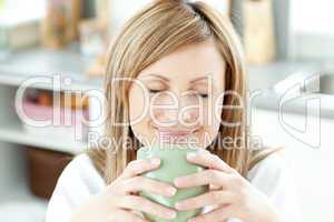 Bright woman holding a cup of coffee in the kitchen