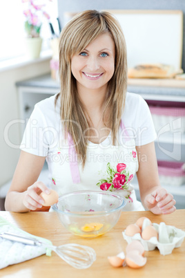 Delighted woman preparing a cake in the kitchen