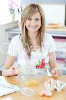 Delighted woman preparing a cake in the kitchen