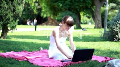 Woman with laptop sitting in the park