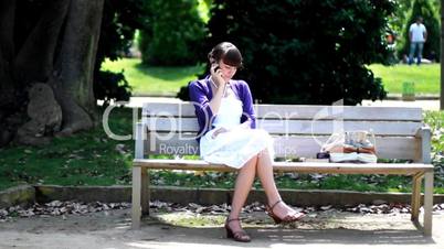Woman sitting in the park and talking on cellphone