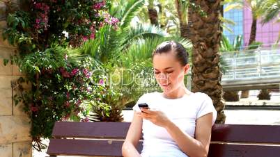 Woman sitting in the park and sending text message