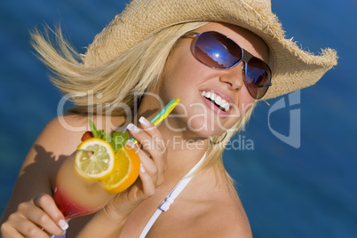 Beautiful Blond Woman Drinking Cocktail By The Sea