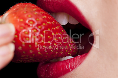 Beautiful Female Lips Mouth and Teeth Eating Strawberry