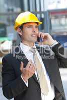 Man In Industrial Hard Hat and Talking On Cell Phone