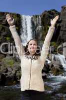 Beautiful Young Woman Celebrating Arms Raise By A Waterfall