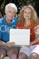 Senior Man and Woman Couple Outside Using Laptop Computer