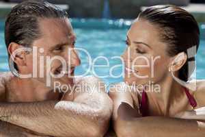 Beautiful Couple Relaxing In Swimming Pool With Perfect Smiles