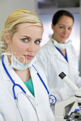 Female Scientific Research Team Using Microscopes in a Laborator