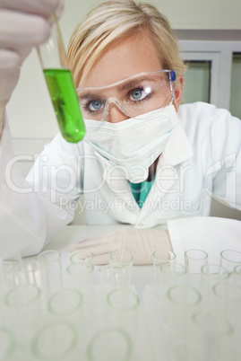 Female Scientist With Test Tube of Green Liquid In Laboratory