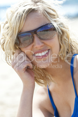 Beautiful Young Blond Woman in Sunglasses Smiling At The Beach