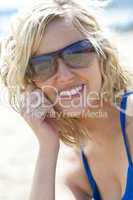 Beautiful Young Blond Woman in Sunglasses Smiling At The Beach