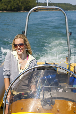 Beautiful Young Blond Woman Driving A Speedboat