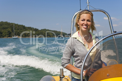 Beautiful Young Blond Woman Driving A Speedboat