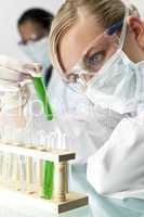 Female Scientist With Test Tube of Green Solution In Laboratory