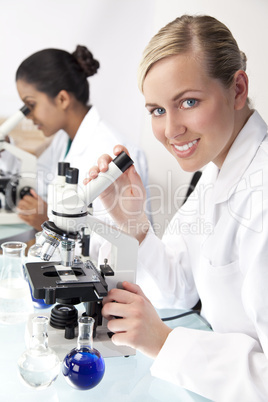 Female Scientific Research Team Using Microscopes in Laboratory