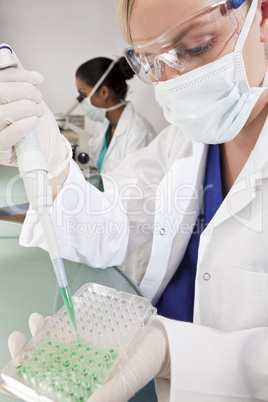 Female Scientist With Pipette and Green Sample Tray In Laborator