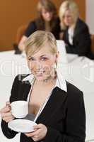 Businesswoman Drinking Coffee In A Busy Office