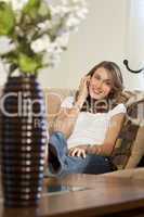 Attractive Young Woman On Her Cell Phone At Home