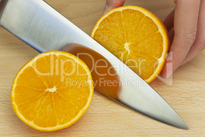 Chef Slicing Fresh Orange With Sharp Kitchen Knife